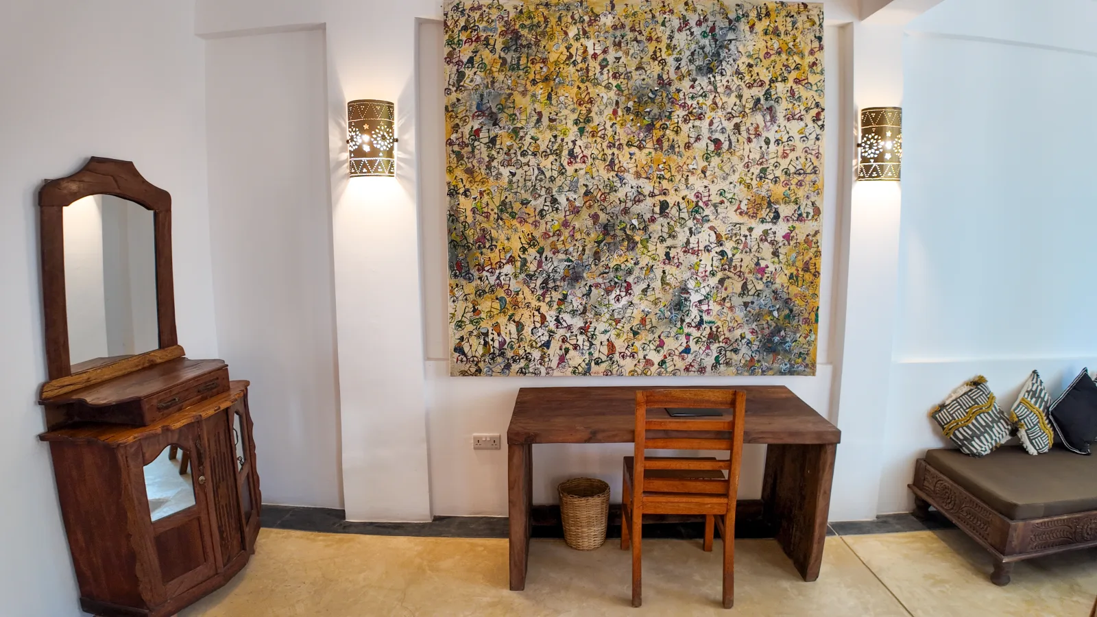 Khole Villa interior detail with a large artwork, writing desk, mirror, and carved furniture