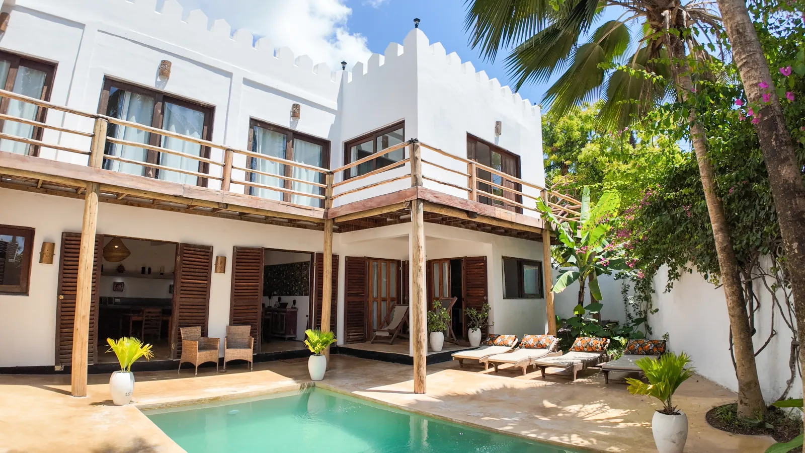 Khole Villa pool and sun loungers beneath a palm tree