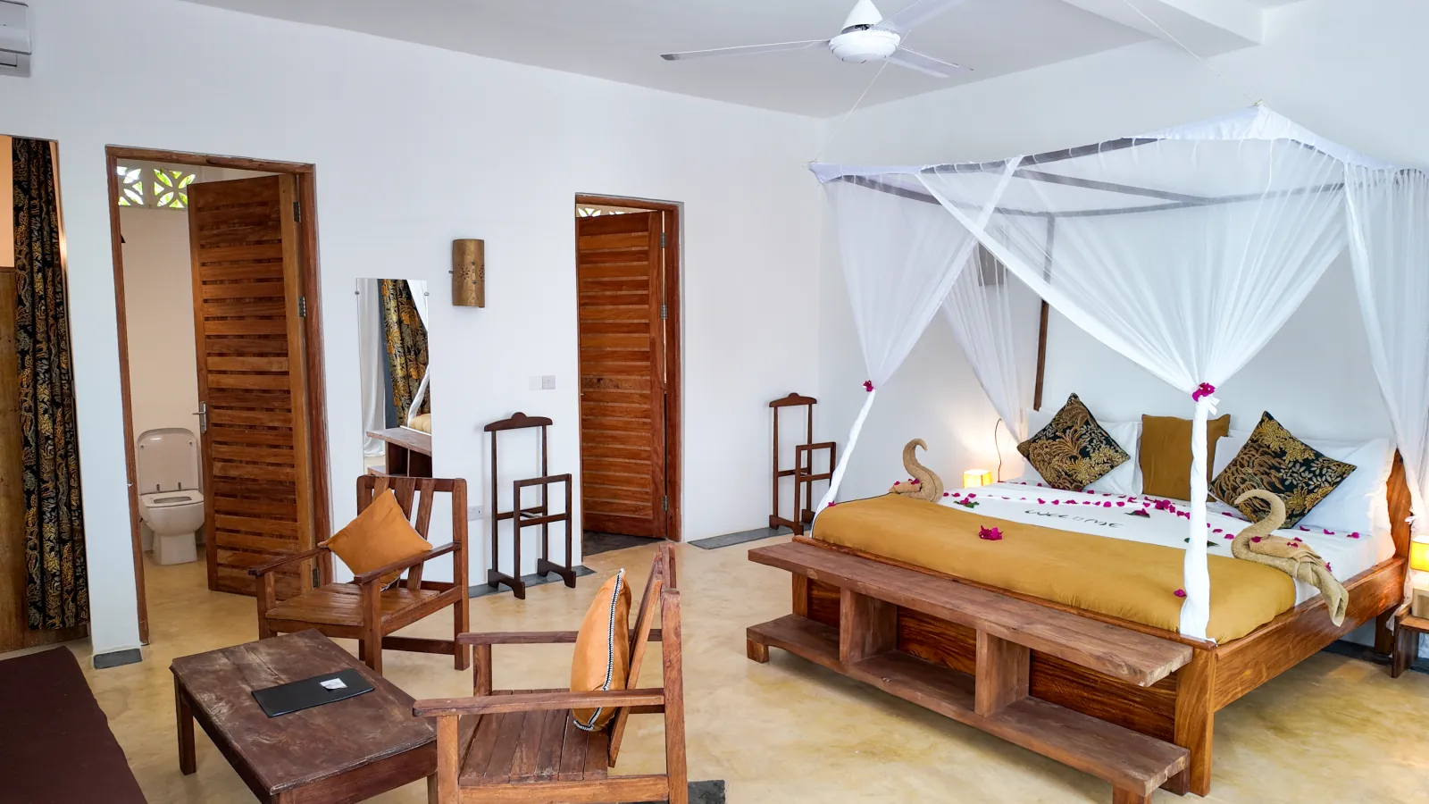 Khole Villa suite with a draped canopy bed and wooden seating area