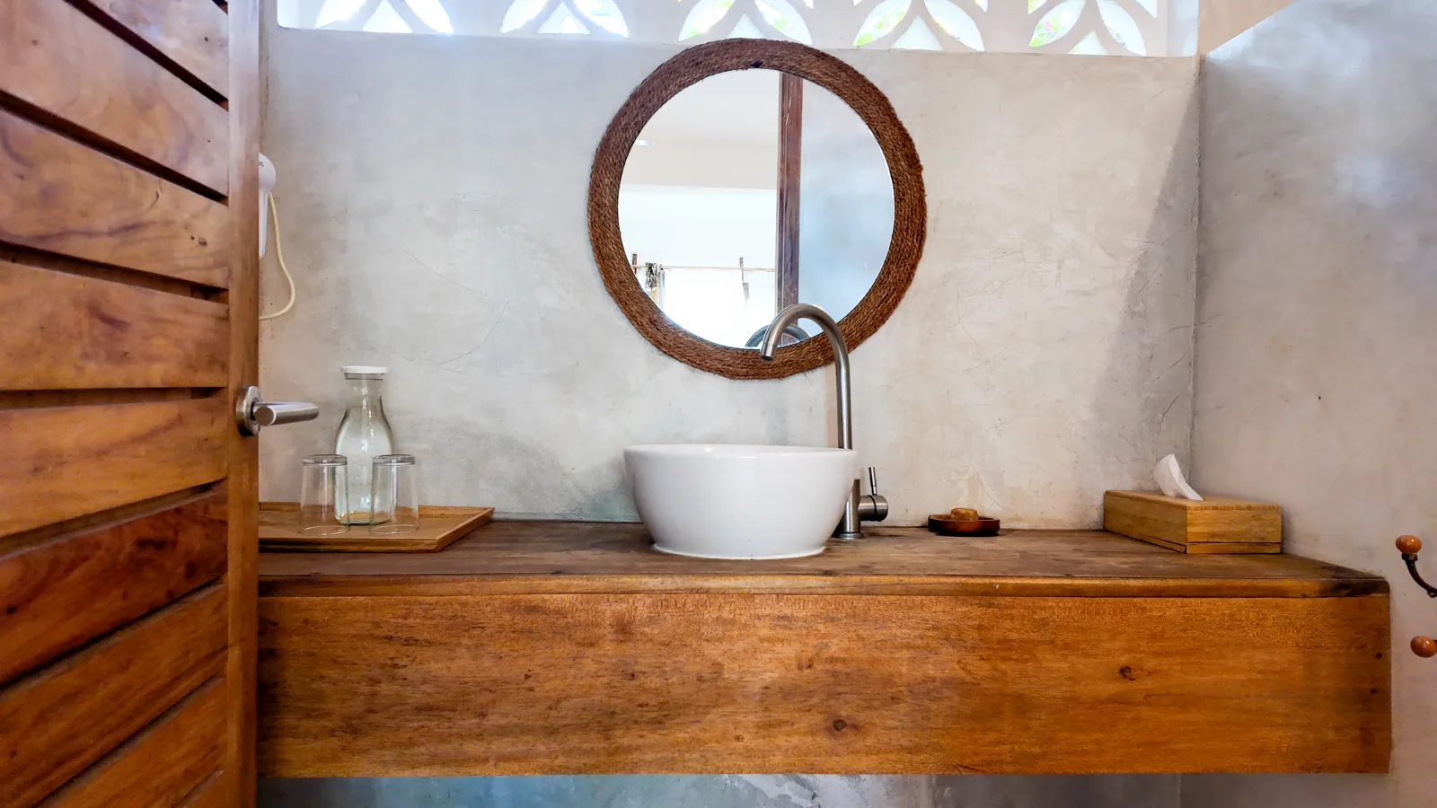 Khole Villa wooden bathroom vanity with a white basin and woven mirror